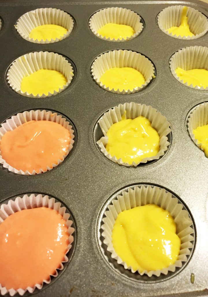 batter layers into cupcake liners for candy corn cupcakes
